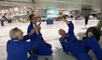 three volunteers underneath an aircraft