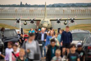 Visitors walking in front of a Hercules aircraft at the RAF Museum Midlands.