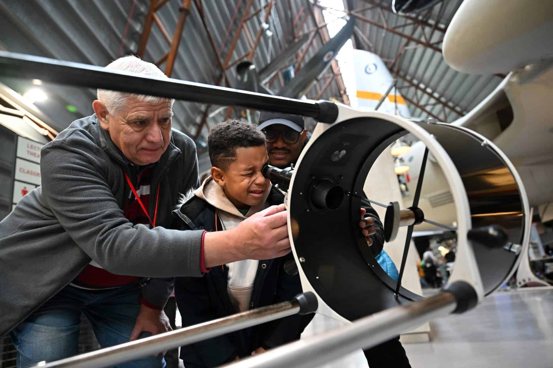 Young boy and older man looking at an object in the museum