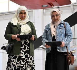 Two ladies hold iPads completing a activity 