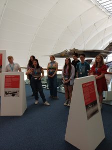 A group of young people next to museum display boards