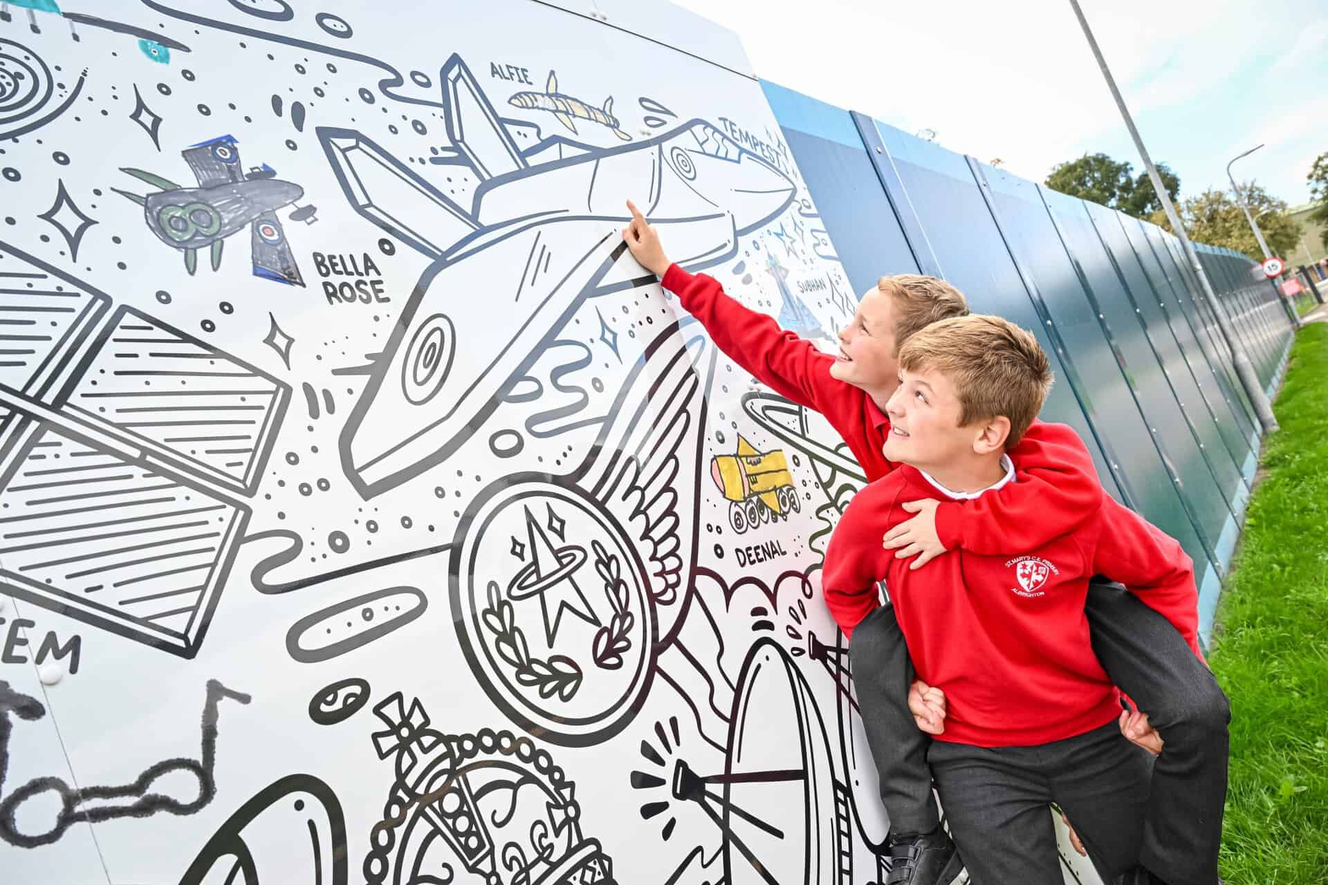Students from St Mary's Primary School in Albrighton view their artwork within the mural at RAF Museum Midlands